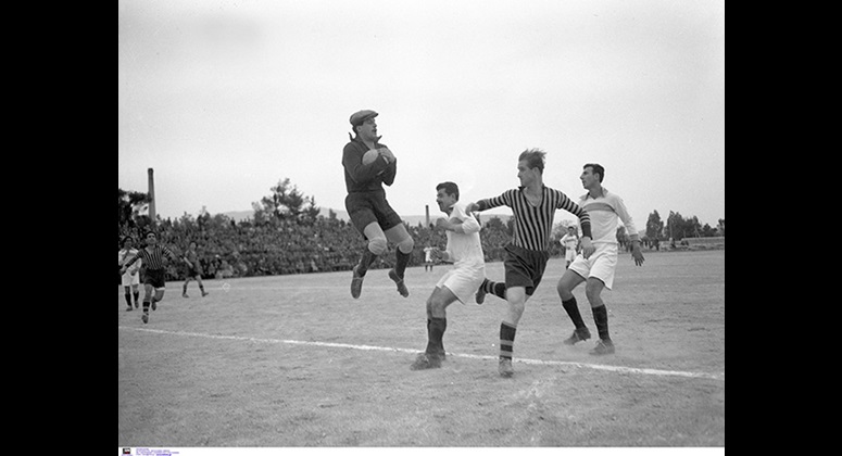 Ο τερματοφύλακας του Απόλλωνα Στάθης Τσανακτσής μπλοκάρει την μπάλα υπό την απειλή του Κλεάνθη Μαρόπουλου σε αγώνα ΑΕΚ-Απόλλωνα το 1950.